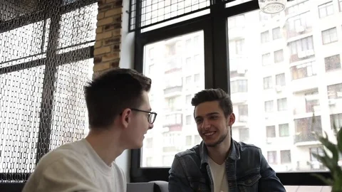 Two buddies sitting in the cafe and chatting with each other Stock Footage 74855435