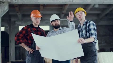 Two builders and foreman engineer study a work plan. Repair service. Business Stock Footage 131692384