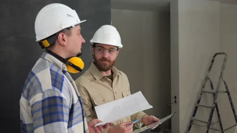 Two builders are explained by improvised objects on the construction site Stock Footage 235541282