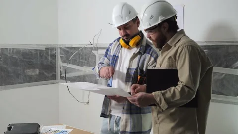 Two builders communicate, talking about the renovation of a new house Stock Footage 235168654