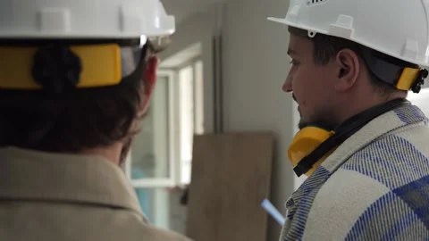 Two builders on the construction site are holding documentation in their hands Stock Footage 236055056