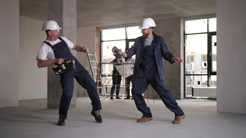 Two builders dancing fun during renovation work Stock Footage 149073392