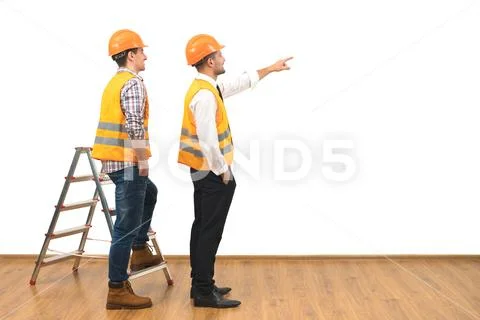 The two builders near ladder gesture on the white wall background Stock Photos
