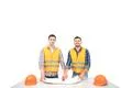 The two builders with a paper on a table stand on the white background Photo