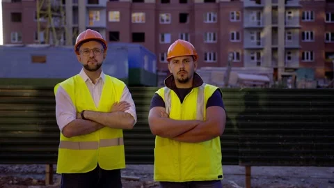 Two builders stand and crosses their hands Vídeo Stock 157713753