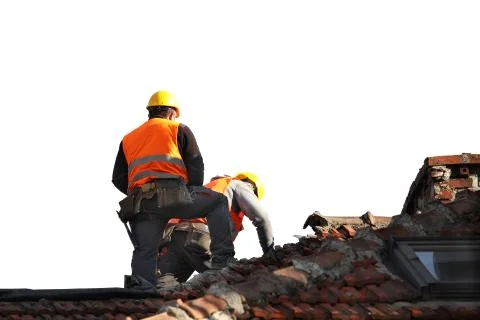 Two builders in working clothes fixing an old tiled roof on a building. Const Stock Photos