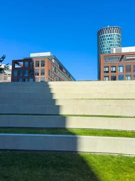 Two buildings stand behind a large concrete staircase. Grass grows in section Stock Photos