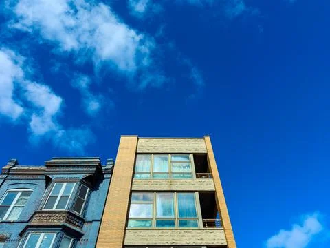 Two buildings stand next to each other in a city. One is made of brick and ha Foto stock