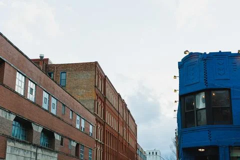 Two buildings stand next to each other in a city. One is an old brick buildin Stock Photos