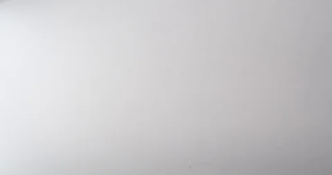 Two bulldog clips fall onto a white table top Stock Footage 117349488