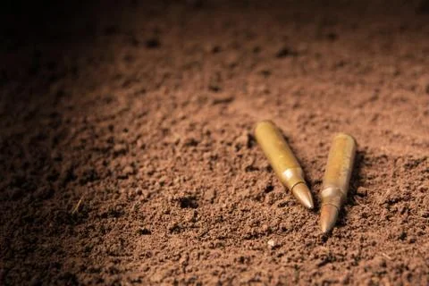 Two bullets, machine gun bullets on soil background Stock Photos