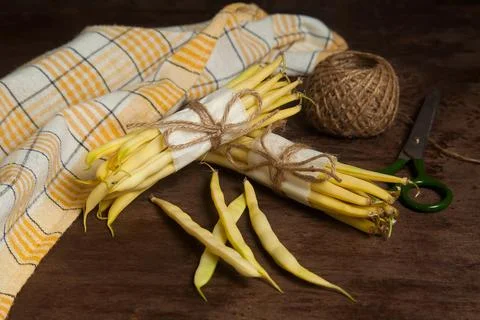 Two bunch and several pods of flat runner bean pods heap with yellow kitche.. Stock Photos