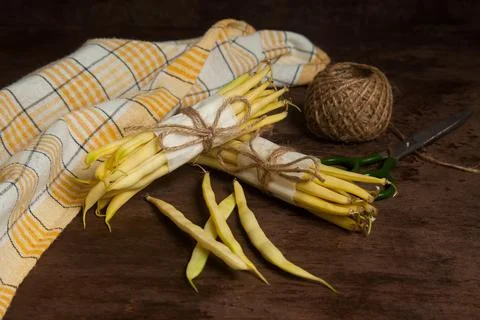 Two bunch and several pods of flat runner bean pods heap with yellow kitche.. Stock Photos