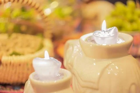 Two burning candles on a blurry background of green grapes Stock Photos