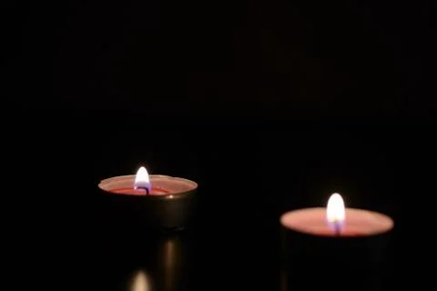 Two burning candles in the dark Stock Photos