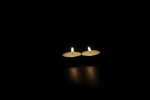 Two burning candles in the dark Stock Photos