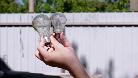 Two burnt light bulbs in female hands Stock Footage 293200295