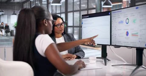 Two Business Analysts Collaborating On Risk Management Using Data Software. Stock Photos
