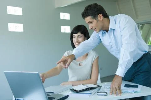 Two business colleagues looking at computer monitor, pointing to screen Stock Photos