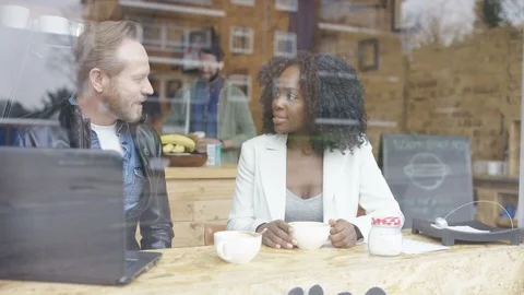 Two business executives having a discussion over coffee at cafe Stock Footage 108002956