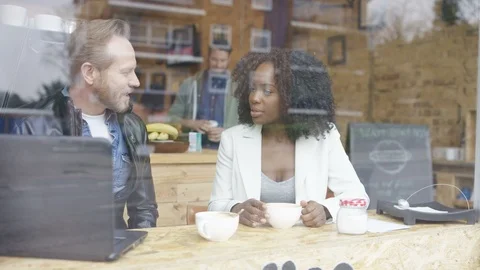 Two business executives having a discussion over coffee at cafe Stock Footage 108003094