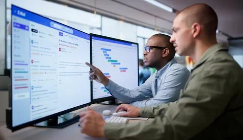 Two Business Managers Discuss Secure Email Platform Solutions On Desktop. 写真素材