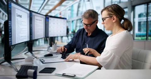Two Business Managers Review Documents Together Before Final Signature Approv 스톡 사진