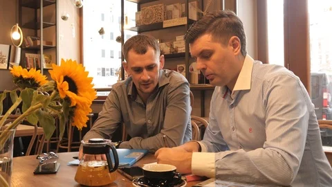 Two Business Men planning work with Pen and Paper on a Lunch in Cafe Stock Footage 87324397
