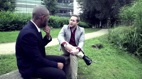 Two Business men sitting on bench and talking Stock Footage 59402537