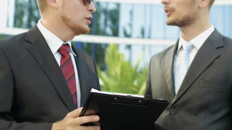 Two business men standing next to an office building to discuss the case Stock Footage 52820711