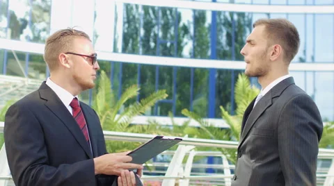 Two business men standing next to an office building to discuss the case Stock Footage 52821223