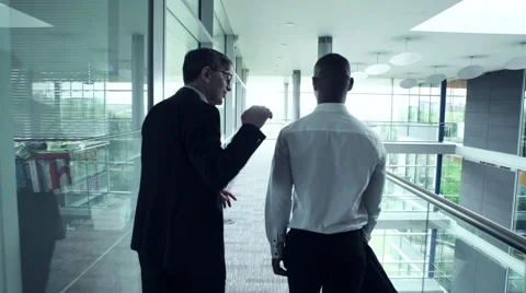 Two Business men talking while walking in office corridor Stock Footage 59398469