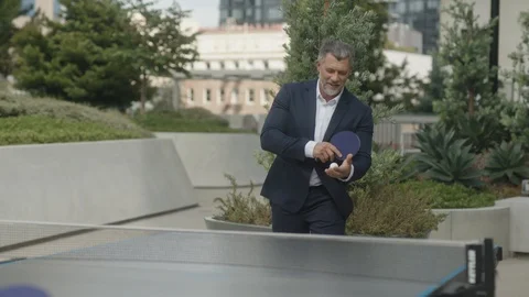 Two business partners play table tennis outside of office Stock Footage 127413409