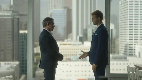 Two business partners shake hands in front of view on downtown LA 스톡 동영상 127412880
