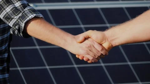 Two business partners shake hands to seal successful deal for solar energy .. Stock Footage 334828655