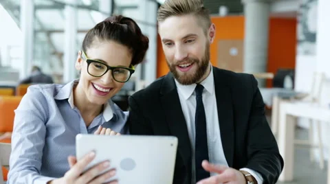Two business partners with tablet talking about some fun stuff Stock Footage 57820451
