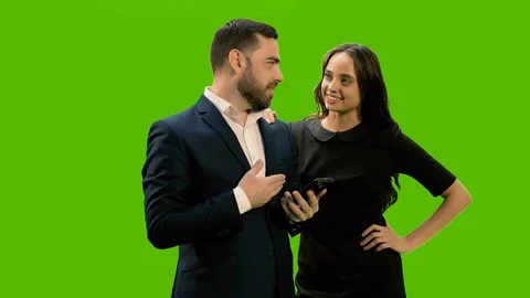 Two business partners using smartphone against green screen background, Chroma Stock Footage 125264074