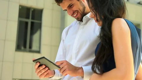 Two business partners using tablet near business center and enjoying good Stock Footage 73812831