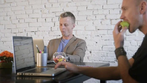 Two business people in the creative office work with laptops and throw colored Stock Footage 91599372