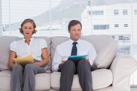 Two business people sitting on couch Stock Photos