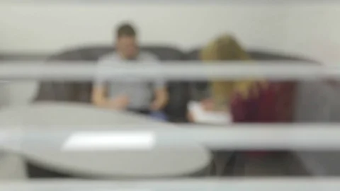 Two business people at table talks, intentionally defocused image Stock Footage 74083296