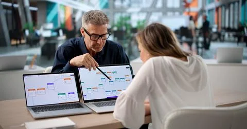 Two Business Professionals Collaborate On Software Workflow Automation Projec Stock Photos