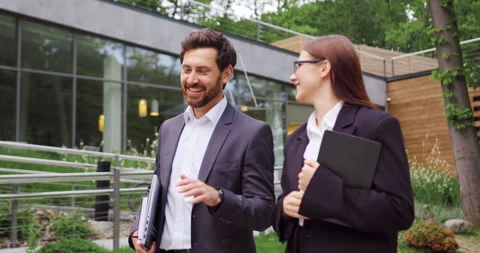 Two business professionals, man and woman walking outdoors near a modern office  Stock Footage 330742290
