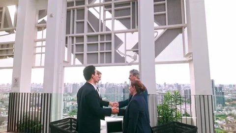 Two business professionals shake hands outdoors on a rooftop. Stock Footage 322217837