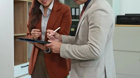 Two business professionals shaking hands in an office, symbolizing partners.. Stock Footage 313461271