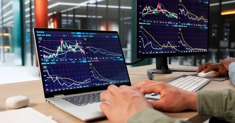 Two Business Professionals Using Computers To Analyze Stock Market Trends Tog 库存照片