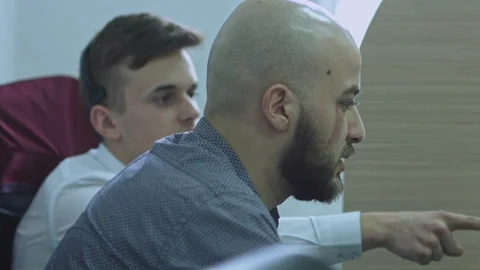 Two business workers discussing in office and looking at computer monitor. One Stock Footage 105811374
