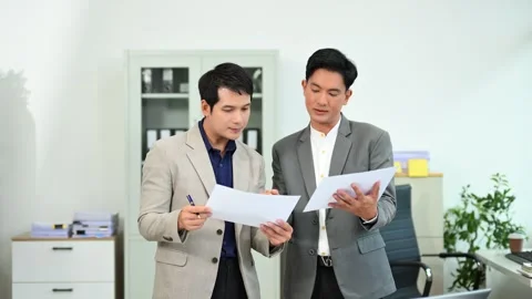 Two business workers talking on the smartphone and using laptop Stock Footage 312714801