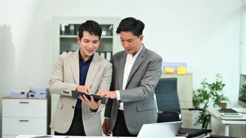 Two business workers talking on the smartphone and using laptop Stock Footage 312714806