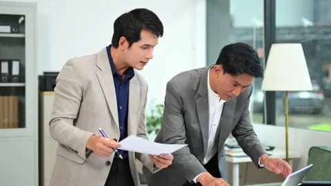 Two business workers talking on the smartphone and using laptop Stock Footage 312714809